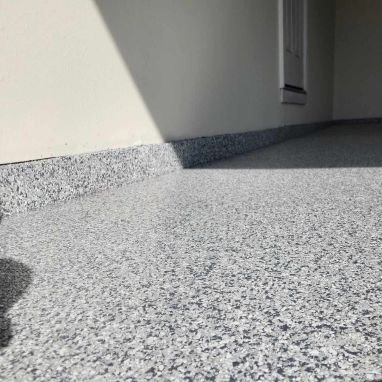 Cove base corner detail on a gray flake epoxy garage floor