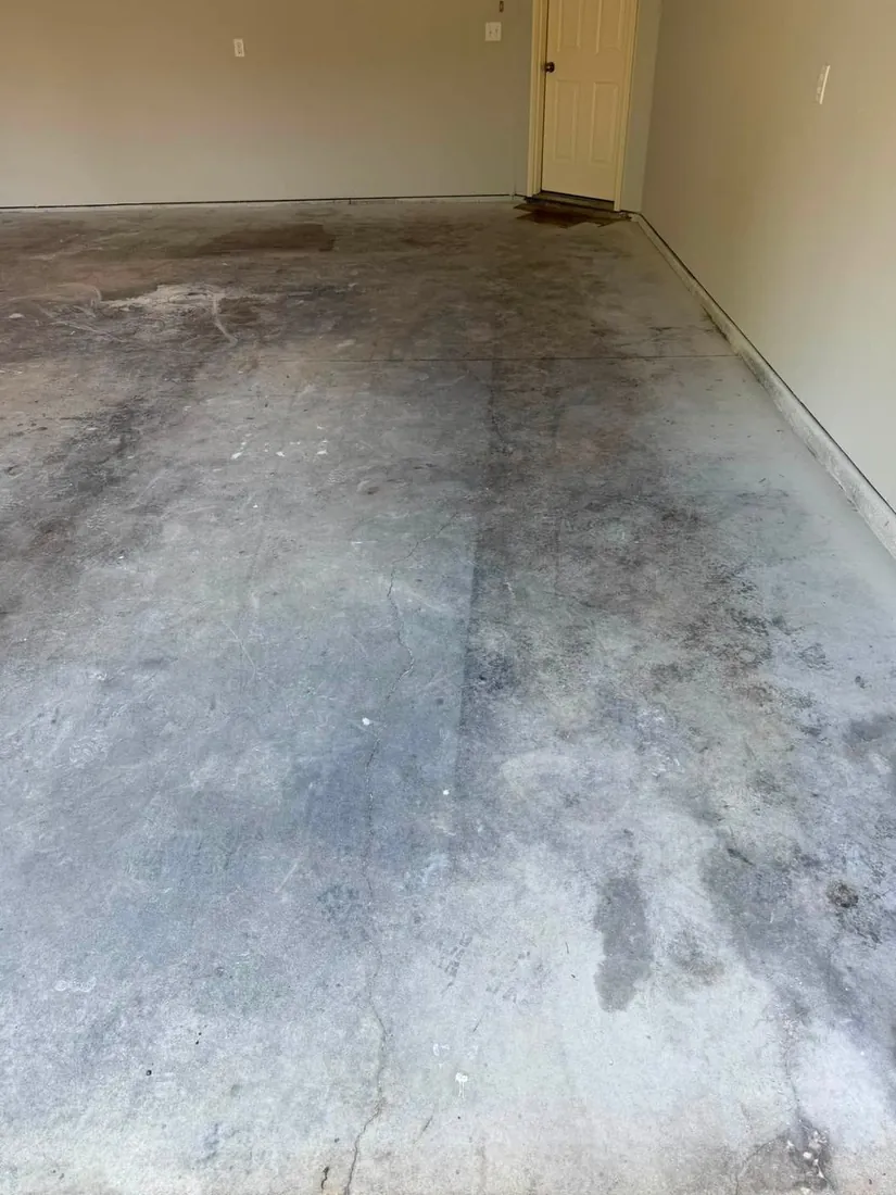 Cracked stained concrete garage floor before epoxy coating Holts Summit Missouri