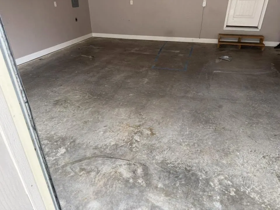 Bare stained concrete garage floor before epoxy coating Wardsville Missouri