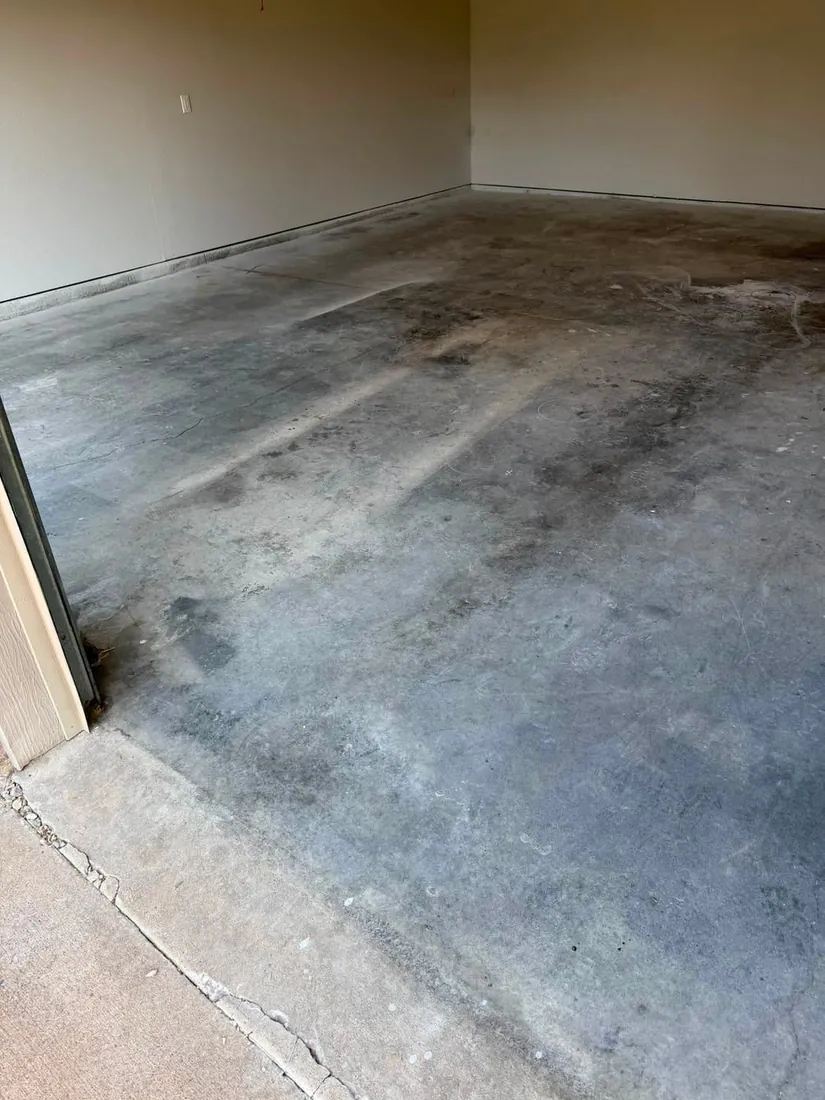 Wide angle bare stained concrete garage floor before epoxy Holts Summit Missouri