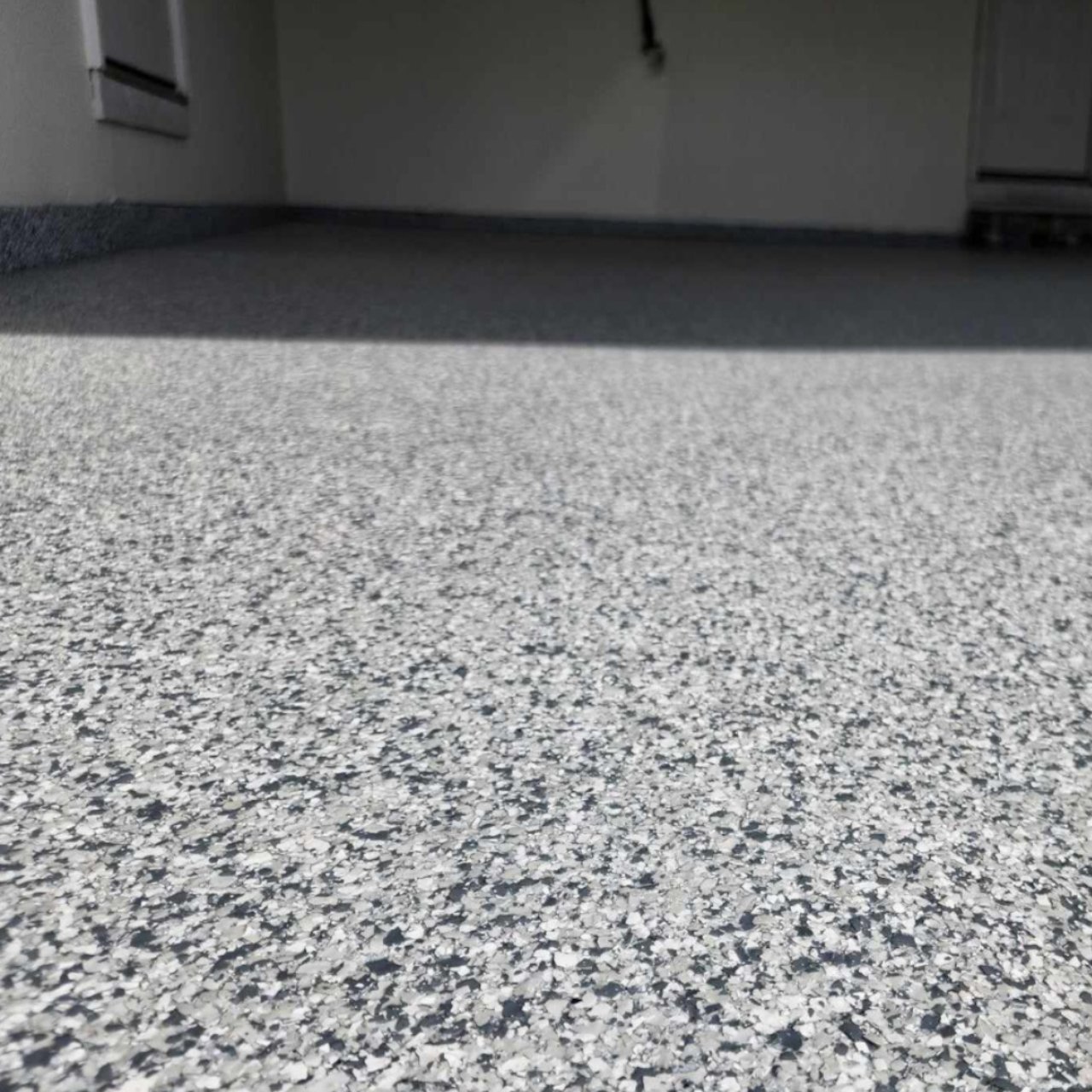 After photo of a large chip gray flake epoxy garage floor installed by Show Me Epoxy