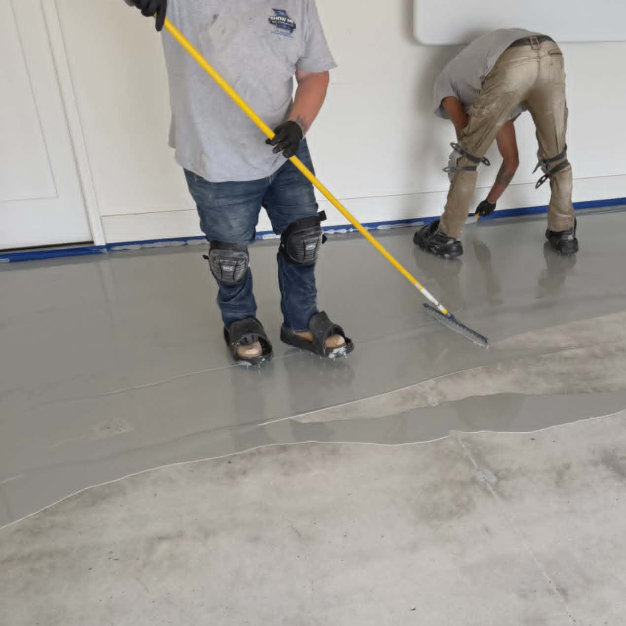 Show Me Epoxy crew applying industrial epoxy base coat to a shop floor