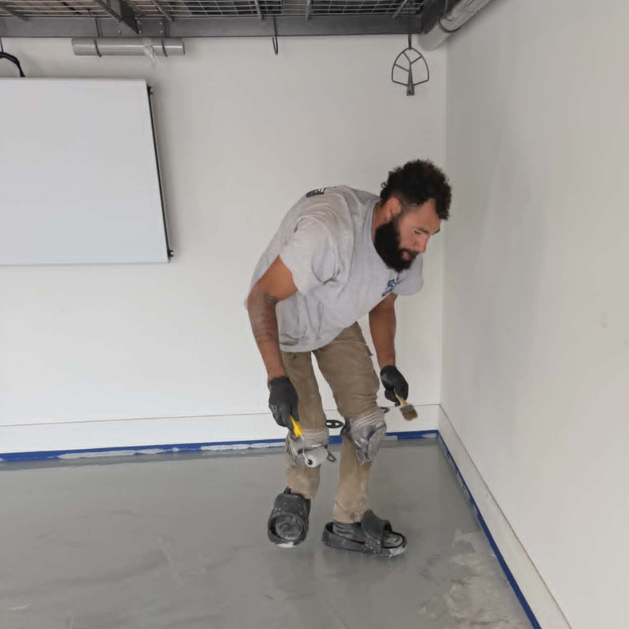 Show Me Epoxy installer cutting in edges on a new garage floor coating