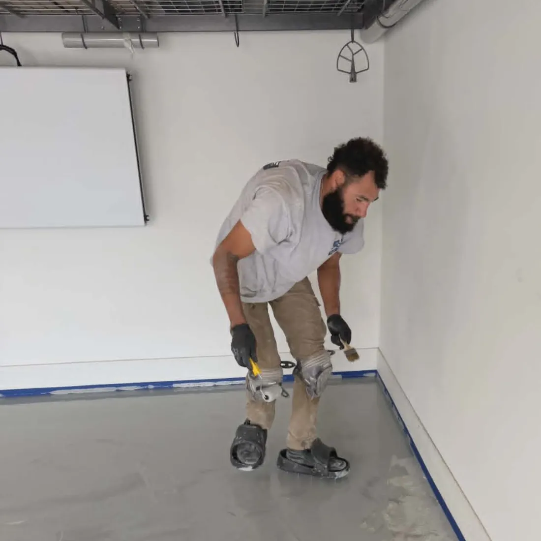 Show Me Epoxy installer cutting in edges on a new garage floor coating