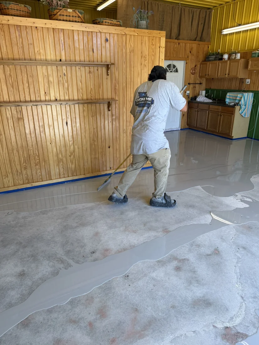 Show Me Epoxy installer rolling epoxy basecoat across a prepped shop floor in Belle Missouri