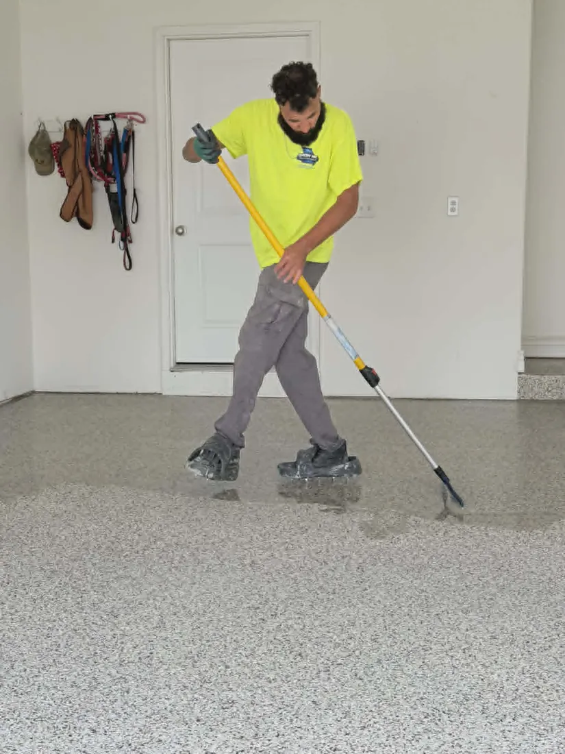 Show Me Epoxy installer spreading epoxy base coat on garage floor Jefferson City Missouri